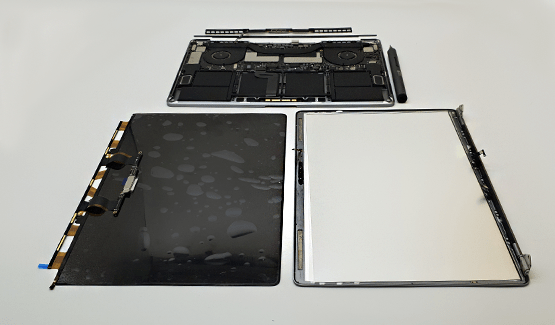מחשב MacBook מפורק עם מסך ומכלולי המארז על שולחן העבודה